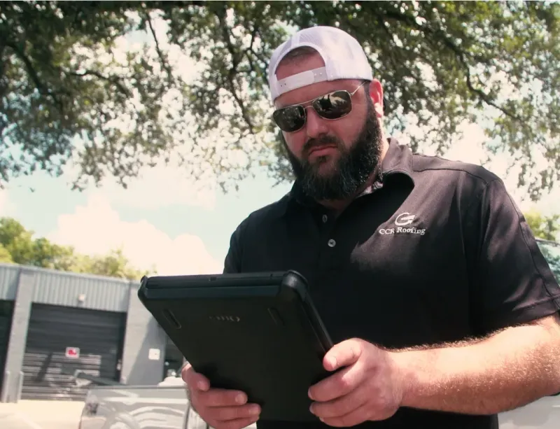 ccr roofing owner aaron on a tablet using hearth